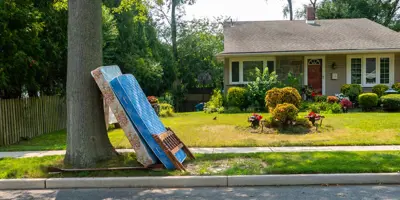 Two mattresses leaning against a tree