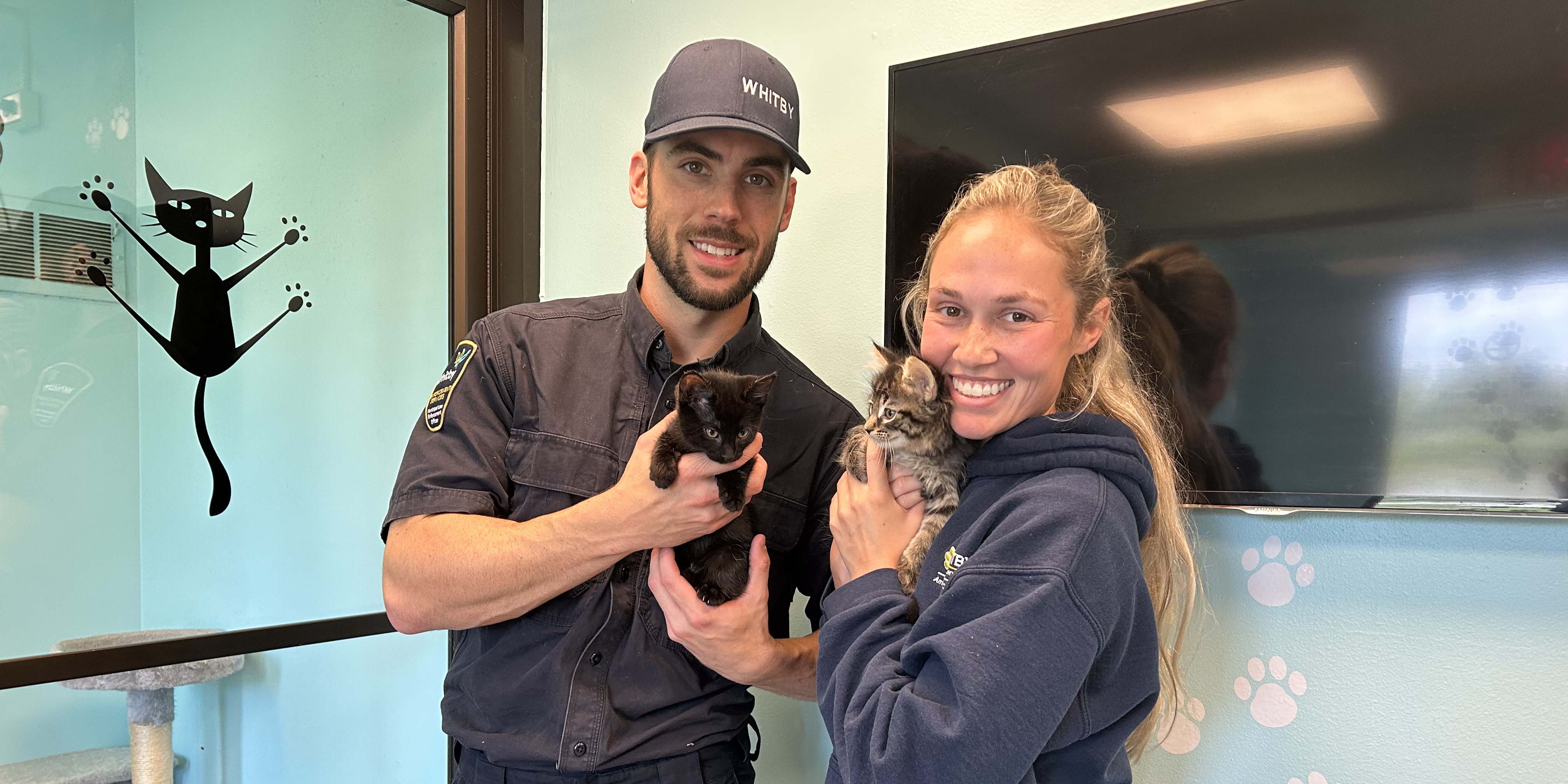 Whitby Animal Services Officers holding kittens.