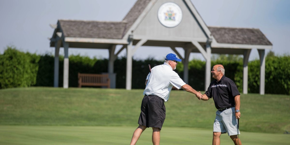 Two people shaking hands on a green of Royal Ashburn Golf Club