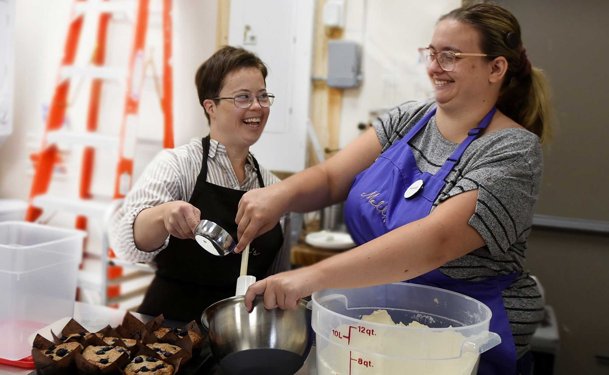 Two staff baking muffins at Melly's Market + Cafe