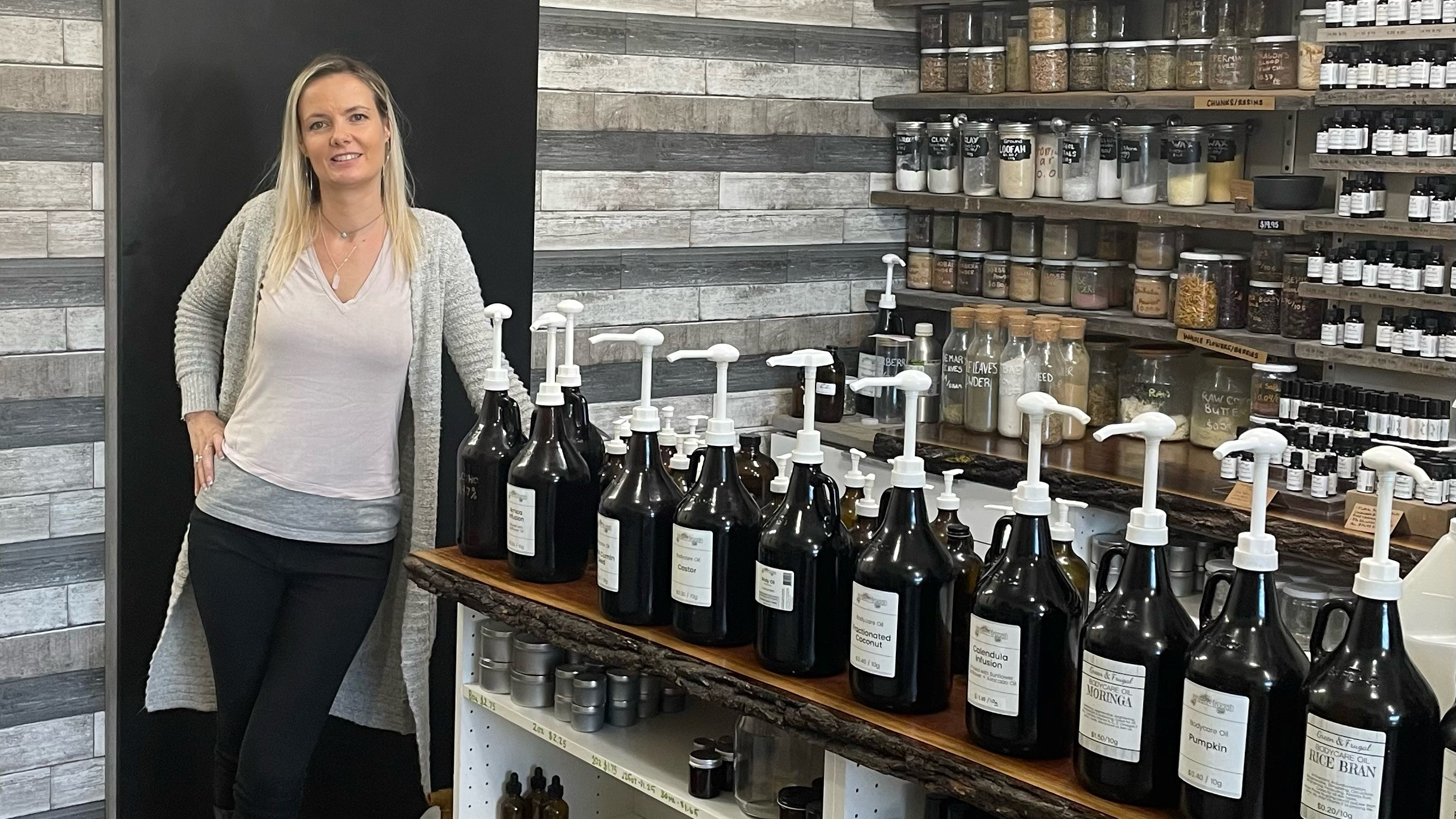 Green and Frugal owner Tara Holguin standing next to products.