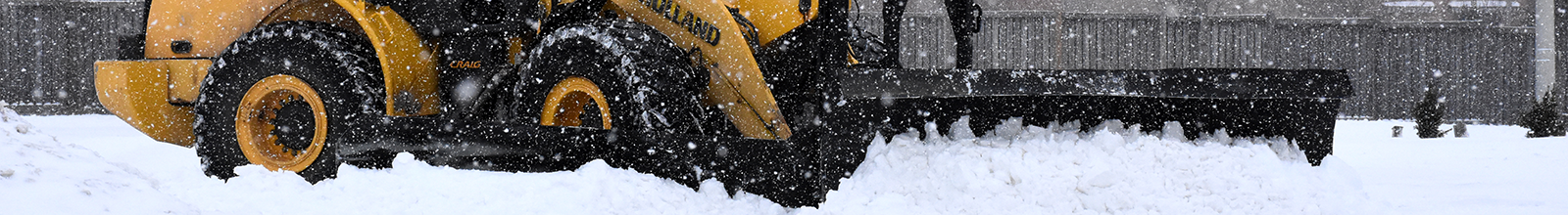 Snow plow clearing snow off road