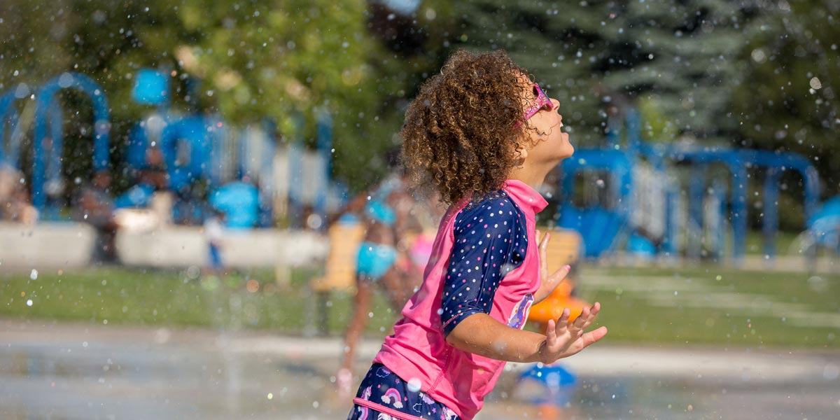 Little girl playing at splash pad