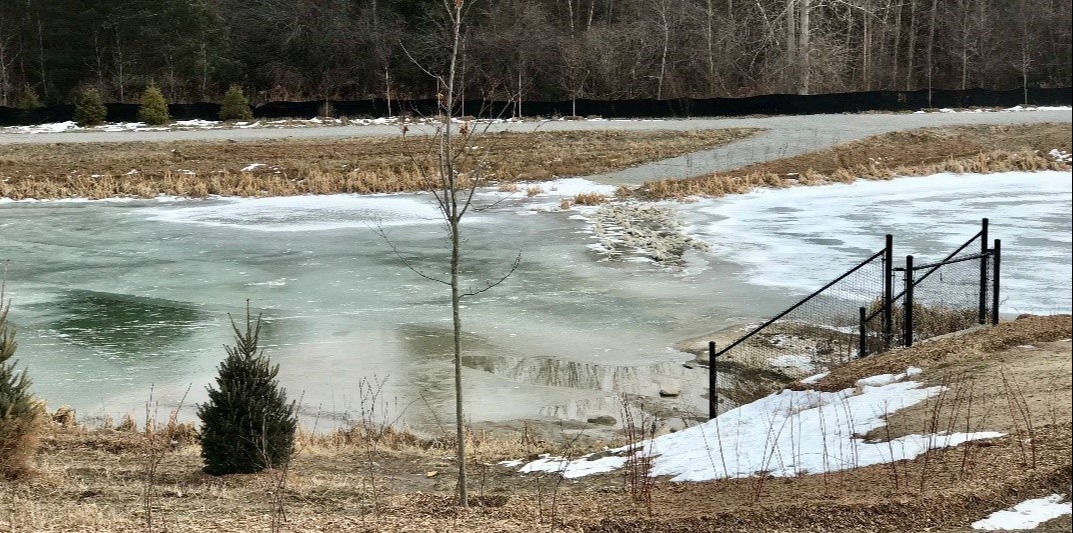 A partially-frozen stormwater pond