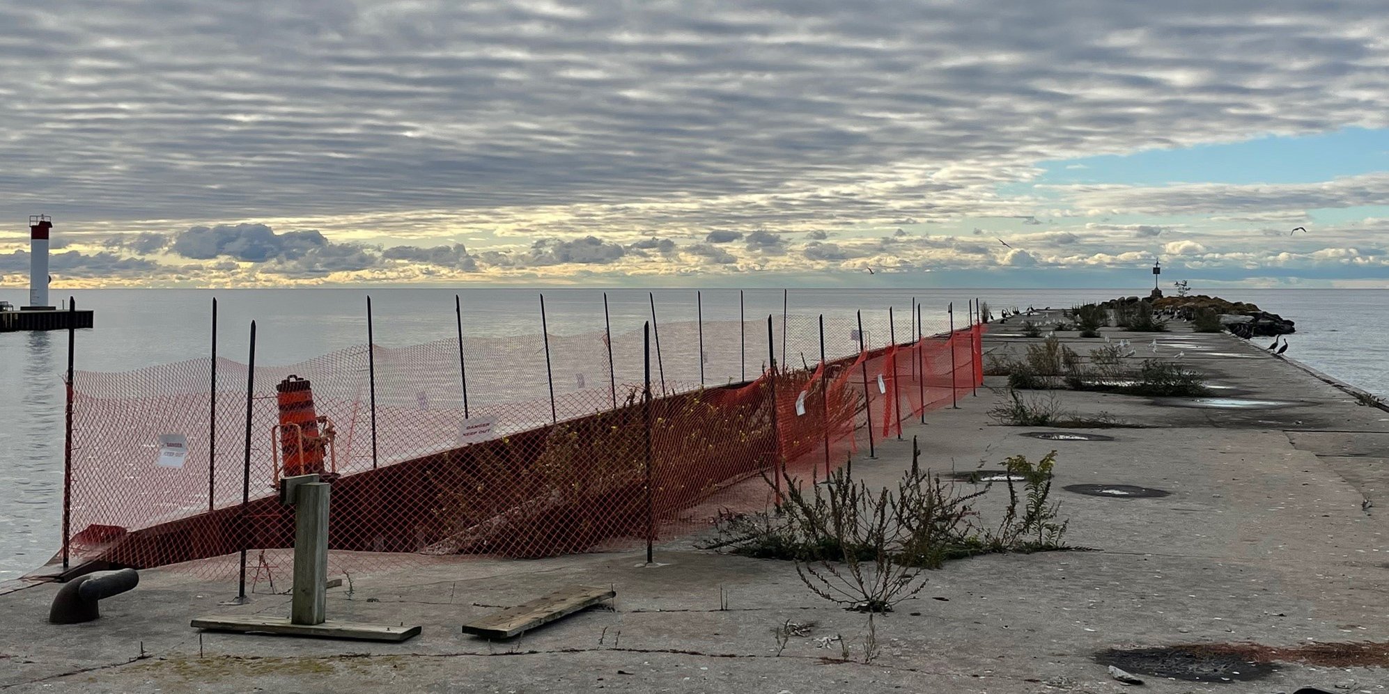 Concrete pier with broken parts and safety fencing.