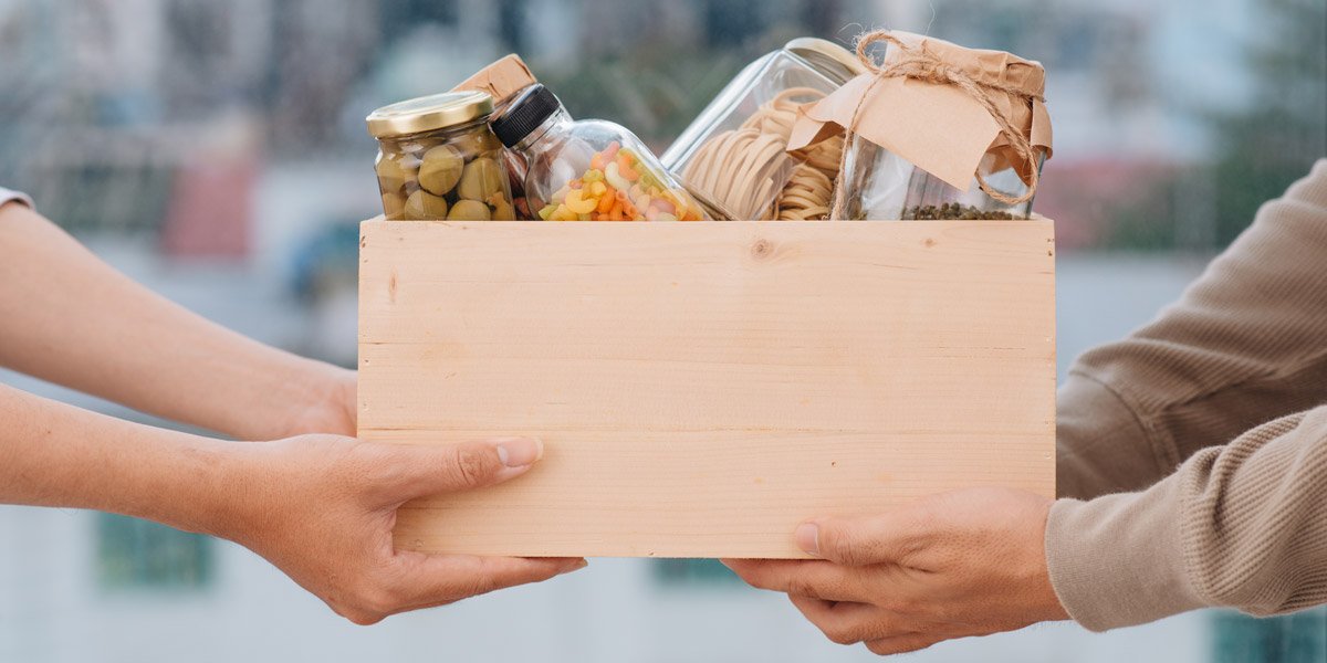People holding a box of canned goods.