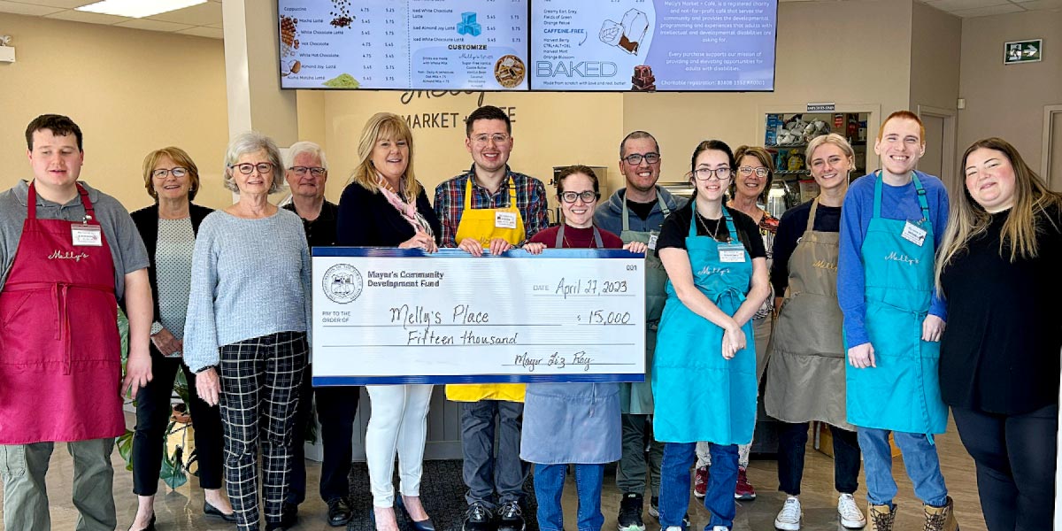 Mayor Roy presenting a cheque to Melly's café 