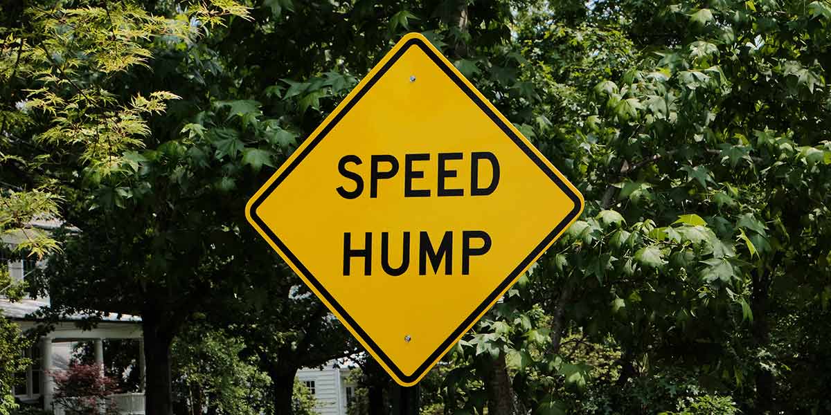 Yellow diamond shape 'Speed Hump' sign