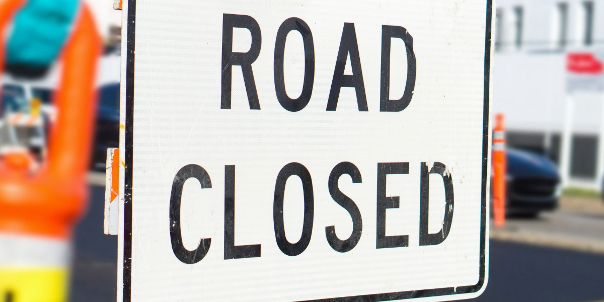 Construction sign with the words road closed.
