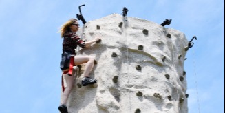 woman climbing rock wall