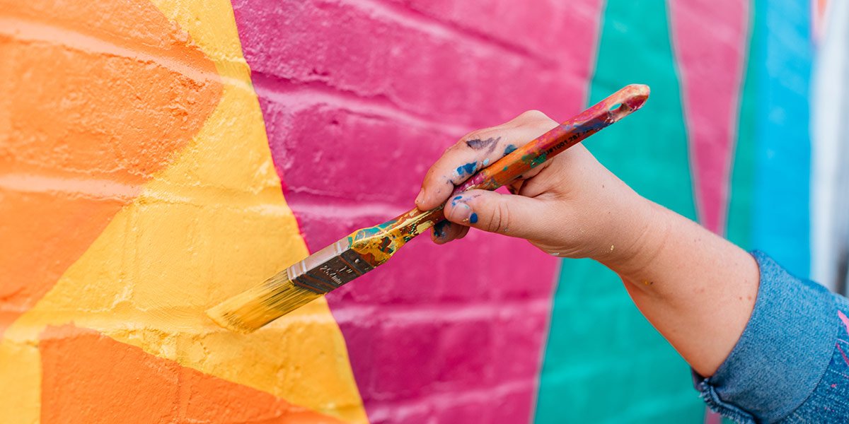 Person painting on a wall