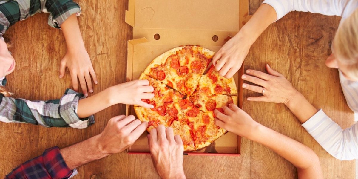 Hands reaching for pizza