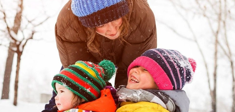 Woman and two children in the snow outdoors