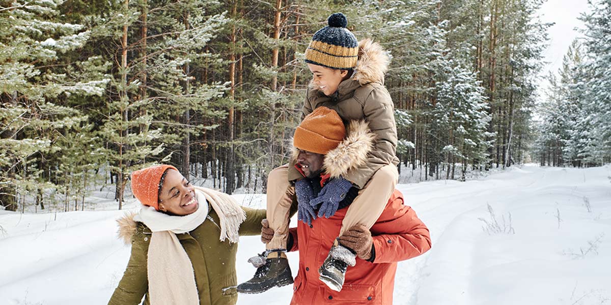 Family walking in the forest with snow