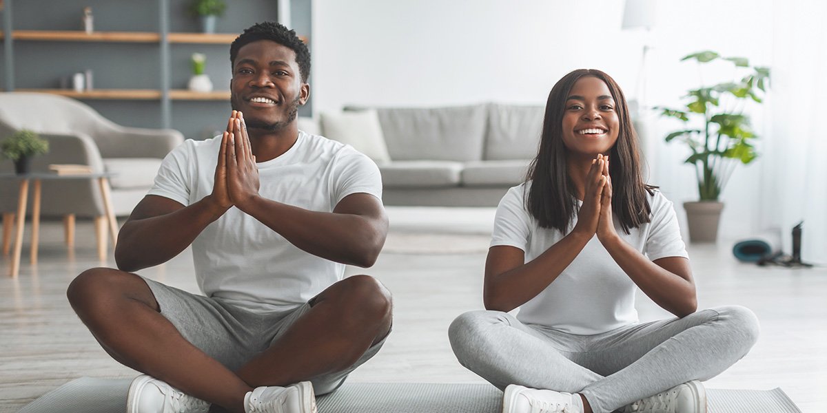 Two people sitting in a yoga pose
