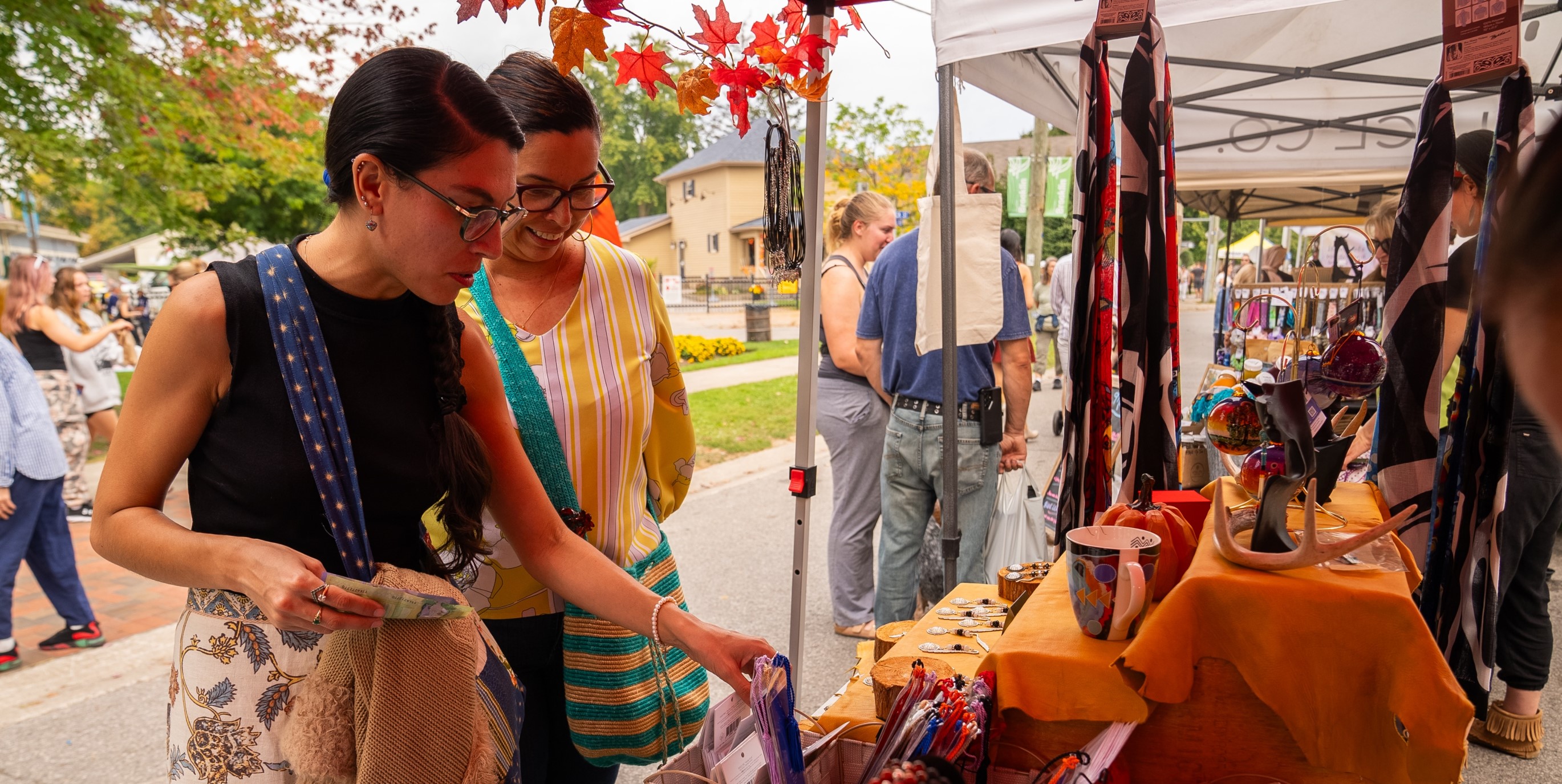 People looking at vendor crafts at harvest festival 