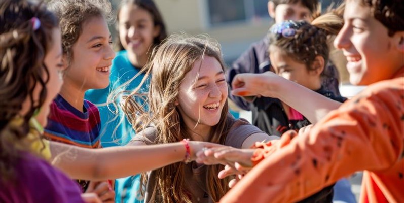 children laughing while dancing outside 
