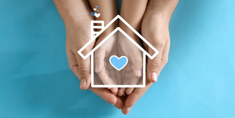Hands holding a house with heart 