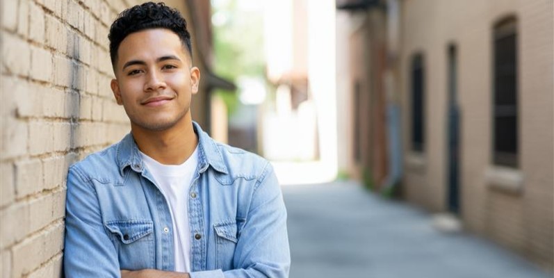 Youth man leaning on wall of alley
