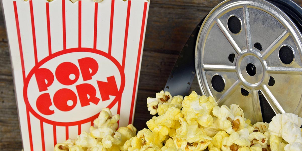 Popcorn box and movie reel on table