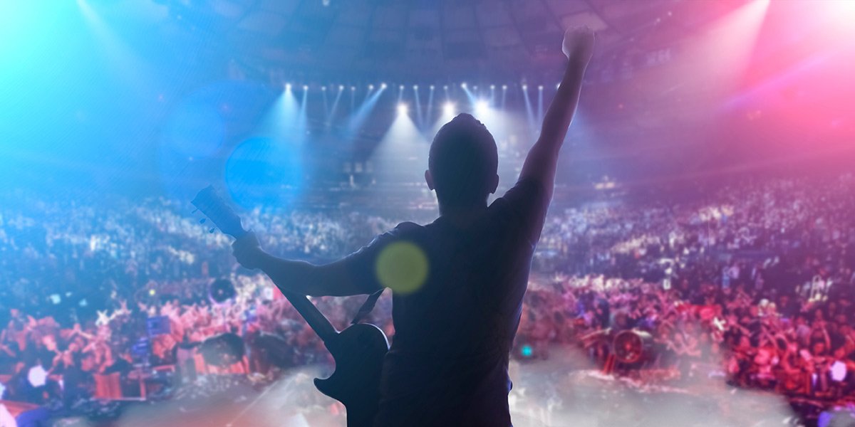 Person standing on stage with guitar