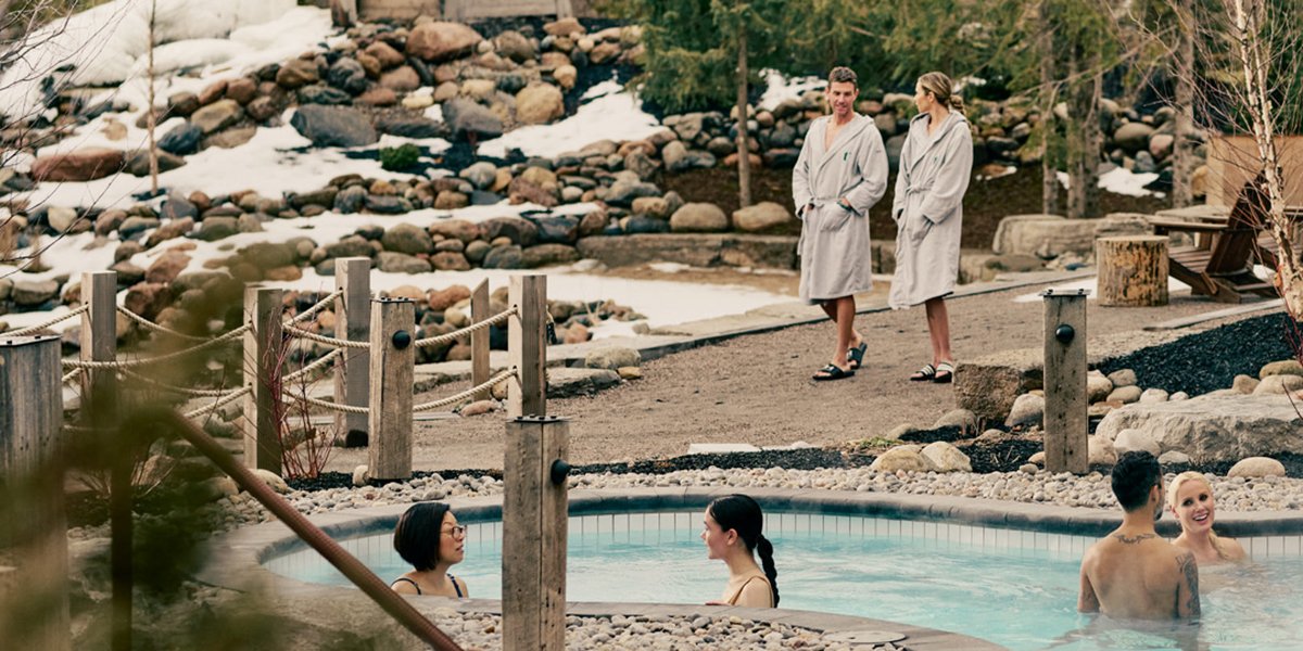 People sitting a pool and people walking on a pathway at a spa