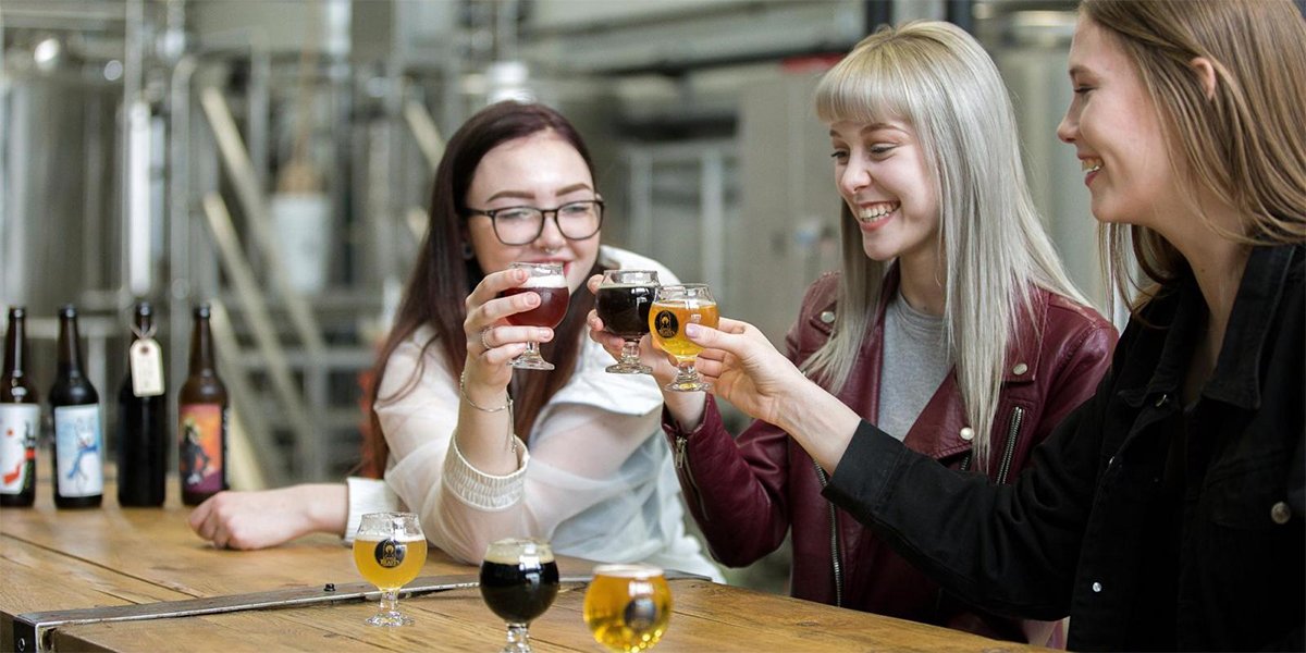 Three women lifting a beer