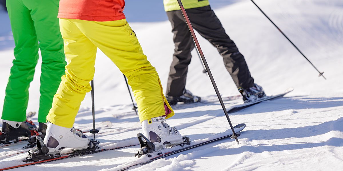 People on snowy hill with skis and poles