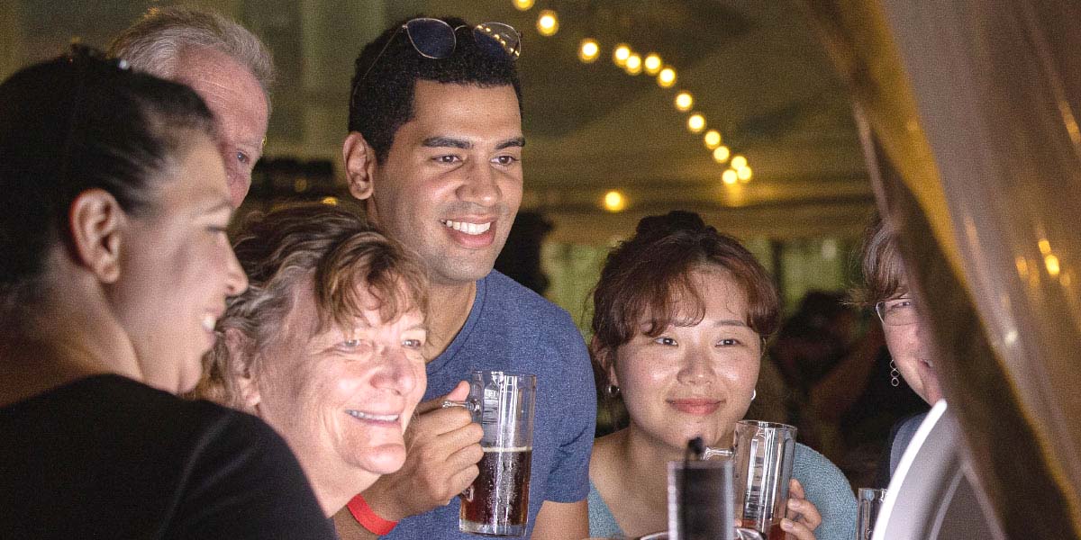 A group of people watching a screen and smiling