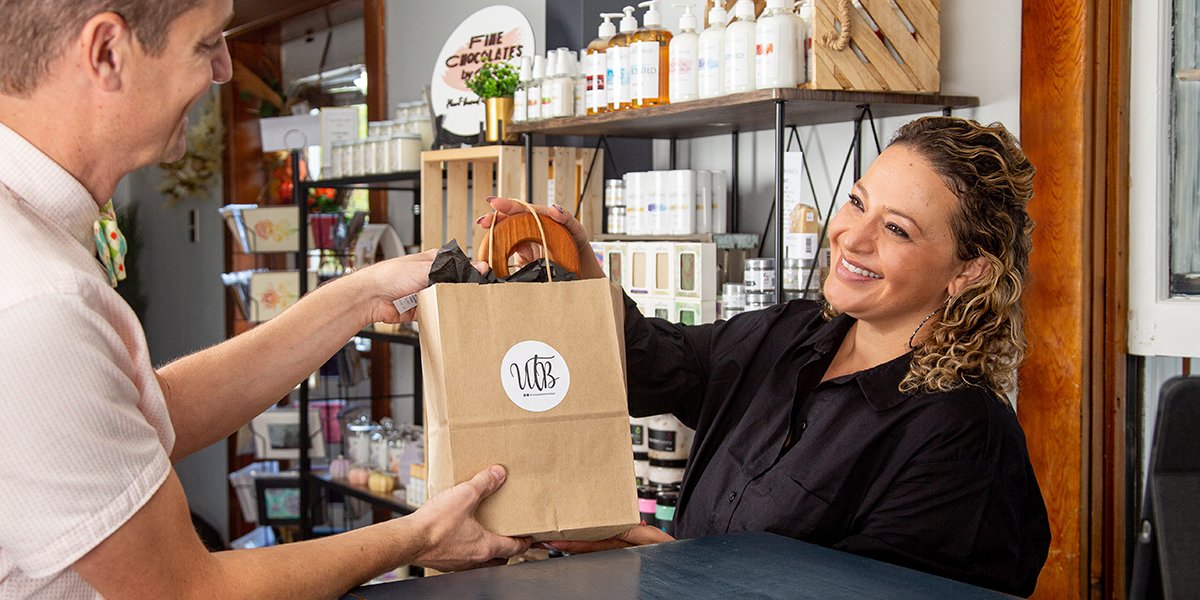 Person handing a person a shopping bag