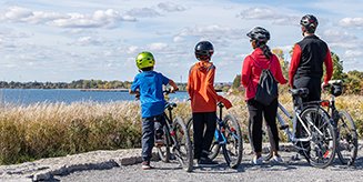 Family on bikes looking over the water