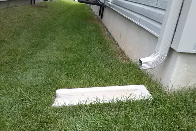 a downspout draining onto a splash pad