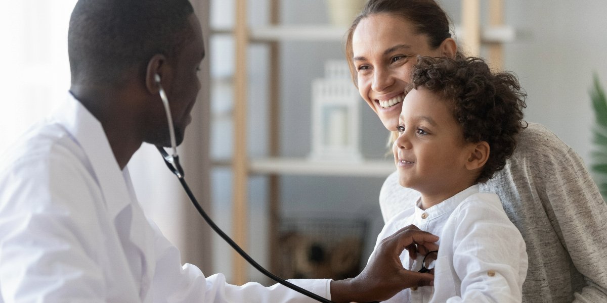 A doctor examining a toddler with a stethoscope