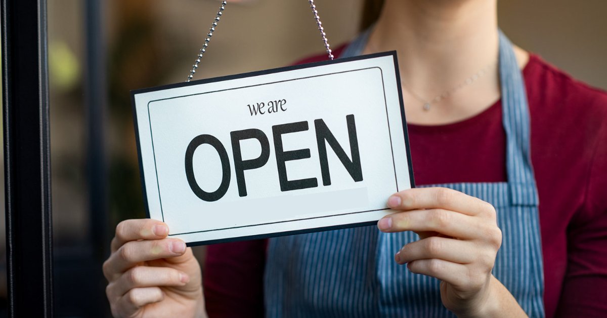 Business owner holding open sign