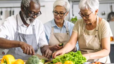 three older adults volunteering in the kitchen