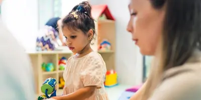 Girl playing with mom in toy room 