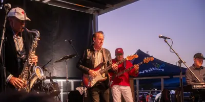 Jack De Kayzer performing on stage with an electric guitar 