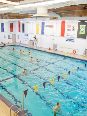 Overhead shot of people swimming at indoor pool 