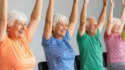 group of older adults stretching while seated