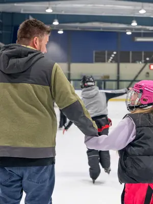 dad and daughter holding hands while skating 