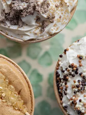 Fancy coffee drinks with whipped cream on tray 