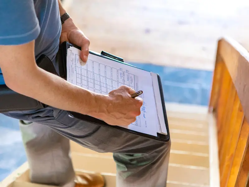 A person filling out a form while standing on the stairs