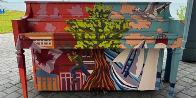 waterfront piano painted with a maple tree and the Whitby Pier 